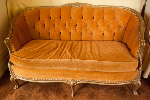 Pair of identical french provincial loveseat sofa ft.s. Wood framed. Apricot colored velvet upholstery. Channel and tufted. Dimensions 31 in. x 56 in. - Extraordinary Auction - Nike Spillson Home Interiors & Furnishings