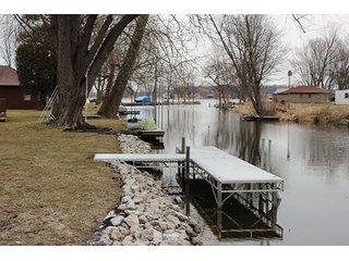 This home offers 980+/- square feet of living space with some furnishings and a 24 x 25 attached two car garage with work space.  Home features a full kitchen with newer range and refrigerator, two or three bedrooms and one full bath with stackable washer and dryer.  The home has ductwork throughout, however the furnace has been removed.  

Great channel front deck for lake view cookouts and new aluminum boat dock with approximately 75' of channel frontage. - Hoffman Lake Channel Front Home
