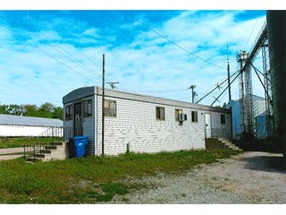 <b>TRACT #1 - GRAIN ELEVATOR</b>  (<b>SOLD - 9/9/16 $110,000</b>)
Note:  The grain bins, drier and legs are on R.R. leased property.  Mr. Voreis stated that lease payment is $900/year.

<b>Improvements - Grain Bins, Drier & Legs:</b>
1994     90,000 bu. bin with air tubes
1994     15,000 bu. hopper bin
               7,000 bu. bin
             42,000 bu. bin with air tube
<b>Drier:</b>  12'x45';1994 Zimmerman grain drier; S.S. 1,500 bu./hr. at 10 pts.;Natural gas
<b>Leg:</b>  1994 110' grain leg; 8,000 bu./hr.
<b>Drier Grain Leg:</b>  5,000 bu./hr.
<b>North Leg:</b>  7,000 bu./hr.
<b>Top Conveyor:</b>  1994 Chain Conveyor
<b>Bottom Conveyor:</b>  U-Trough Auger
<b>Dump Pit:</b>  Approx. 150 bu. with auger to leg

<b>Office:  Portable</b>  A 10' x 50' office with 2 separate offices, customer counter area, 1 restroom

<b>Grain Probe:</b>  A Hyd. Grain Probe

<b>Scales:</b>  10' x 60' Metal deck, scales, load cells, 100,000 lb. capacity, digital read-out and printer

<b>Quonset:</b>  A 41' x 120' metal Quonset building with concrete floor, top auger with 70,000 bu. capacity.

<b>Shop:</b>  A 22' x 40' wood frame with metal siding, concrete floor, heater

<b>Rail Siding:</b>  7+ Car rail siding along the east side of the grain bins.

<b>Utilities:</b>  City - Water and sewer; Electric - 480 (4) phase; Gas - Nipsco 

<FONT FACE="Arial, Helvetica, sans-serif" size="2" color="#0000FF"><b>TRACT #2 - STORAGE WAREHOUSE</b> (<b>STILL AVAILABLE</b>)

<b>2 Lots, Improvements</b>  60' x 112' wood frame structure, concrete floors, 4 doors, dock high load-out.</font face>



 - Grain Elevator (SOLD - 9/9/16) Storage Warehouse Still Available