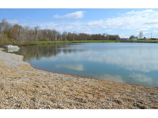 28.5+/- ACRES, a beautiful getaway featuring a well stocked 9 acre, 20+ foot deep lake stocked with bass, bluegill, and have caught large pike occasionally.  Formerly a gravel pit, this lake is bordered by groomed lawn grasses with a very large gravel beach to the lake for great swimming!!  A good sized metal building with covered porch, perfect for weekend and overnight stays.  Adjacent to the St. Joseph River with over 3,000 feet of river frontage, this property has wonderful scenic river views, where deer and turkey travel abundantly, and offers great duck and goose hunting on the lake!  
A great put-in site for river canoe and kayak trips, it offers a wonderful potential building site for year round home or private getaway!  And would also be a wonderful RV and Camper getaway spot!!  Only about a 40 minute drive from Fort Wayne, 30 minutes from Grabill, 20 minutes from Bryan, 35 minutes from Defiance, 30 minutes from Auburn! - 28.5+/- Acres with 9+/- acre Lake, Woods, Possible Building Sites