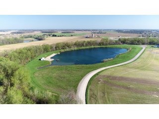 28.5+/- ACRES, a beautiful getaway featuring a well stocked 9 acre, 20+ foot deep lake stocked with bass, bluegill, and have caught large pike occasionally.  Formerly a gravel pit, this lake is bordered by groomed lawn grasses with a very large gravel beach to the lake for great swimming!!  A good sized metal building with covered porch, perfect for weekend and overnight stays.  Adjacent to the St. Joseph River with over 3,000 feet of river frontage, this property has wonderful scenic river views, where deer and turkey travel abundantly, and offers great duck and goose hunting on the lake!  
A great put-in site for river canoe and kayak trips, it offers a wonderful potential building site for year round home or private getaway!  And would also be a wonderful RV and Camper getaway spot!!  Only about a 40 minute drive from Fort Wayne, 30 minutes from Grabill, 20 minutes from Bryan, 35 minutes from Defiance, 30 minutes from Auburn! - 28.5+/- Acres with 9+/- acre Lake, Woods, Possible Building Sites