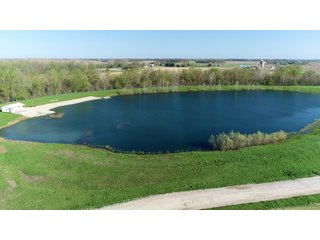 28.5+/- ACRES, a beautiful getaway featuring a well stocked 9 acre, 20+ foot deep lake stocked with bass, bluegill, and have caught large pike occasionally.  Formerly a gravel pit, this lake is bordered by groomed lawn grasses with a very large gravel beach to the lake for great swimming!!  A good sized metal building with covered porch, perfect for weekend and overnight stays.  Adjacent to the St. Joseph River with over 3,000 feet of river frontage, this property has wonderful scenic river views, where deer and turkey travel abundantly, and offers great duck and goose hunting on the lake!  
A great put-in site for river canoe and kayak trips, it offers a wonderful potential building site for year round home or private getaway!  And would also be a wonderful RV and Camper getaway spot!!  Only about a 40 minute drive from Fort Wayne, 30 minutes from Grabill, 20 minutes from Bryan, 35 minutes from Defiance, 30 minutes from Auburn! - 28.5+/- Acres with 9+/- acre Lake, Woods, Possible Building Sites