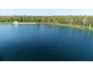 28.5+/- ACRES, a beautiful getaway featuring a well stocked 9 acre, 20+ foot deep lake stocked with bass, bluegill, and have caught large pike occasionally.  Formerly a gravel pit, this lake is bordered by groomed lawn grasses with a very large gravel beach to the lake for great swimming!!  A good sized metal building with covered porch, perfect for weekend and overnight stays.  Adjacent to the St. Joseph River with over 3,000 feet of river frontage, this property has wonderful scenic river views, where deer and turkey travel abundantly, and offers great duck and goose hunting on the lake!  
A great put-in site for river canoe and kayak trips, it offers a wonderful potential building site for year round home or private getaway!  And would also be a wonderful RV and Camper getaway spot!!  Only about a 40 minute drive from Fort Wayne, 30 minutes from Grabill, 20 minutes from Bryan, 35 minutes from Defiance, 30 minutes from Auburn! - 28.5+/- Acres with 9+/- acre Lake, Woods, Possible Building Sites