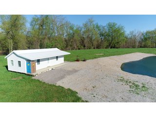 28.5+/- ACRES, a beautiful getaway featuring a well stocked 9 acre, 20+ foot deep lake stocked with bass, bluegill, and have caught large pike occasionally.  Formerly a gravel pit, this lake is bordered by groomed lawn grasses with a very large gravel beach to the lake for great swimming!!  A good sized metal building with covered porch, perfect for weekend and overnight stays.  Adjacent to the St. Joseph River with over 3,000 feet of river frontage, this property has wonderful scenic river views, where deer and turkey travel abundantly, and offers great duck and goose hunting on the lake!  
A great put-in site for river canoe and kayak trips, it offers a wonderful potential building site for year round home or private getaway!  And would also be a wonderful RV and Camper getaway spot!!  Only about a 40 minute drive from Fort Wayne, 30 minutes from Grabill, 20 minutes from Bryan, 35 minutes from Defiance, 30 minutes from Auburn! - 28.5+/- Acres with 9+/- acre Lake, Woods, Possible Building Sites