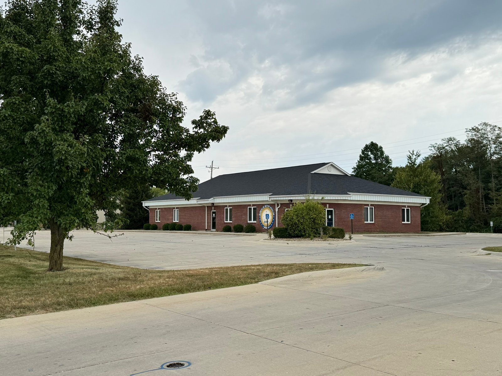 Outstanding opportunity to acquire a commercial property in Greencastle, IN with a proven long-term tenant. This site has been home to the Indiana Bureau of Motor Vehicles for more than 20 years under a favorable lease, ensuring minimal landlord responsibilities. With the current tenant there are no real estate taxes on the property.
The property spans 0.98+/- acres and includes a 4,947+/- sq ft building, built in 2004, along with a 15,180+/- sq ft parking lot providing ample customer convenience. The location is excellent - situated in Greencastle  Township, just East of Greencastle High School. With easy access from Veterans Memorial Highway (US-231) via Mill Pond Drive, the site benefits from both visibility and accessibility.
With a strong, creditworthy tenant and reliable cash flow, this property is an ideal choice for investors looking for secure, long-term income in a community-centered market. - COMMERCIAL REAL ESTATE FOR SALE - .98+/-ACRES IN PUTNAM COUNTY, INDIANA