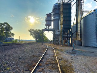 The Frick Grain and Agronomy site facilities are situated on approximately 35+/- acres and represent a rare, large-scale agribusiness operation ready for immediate use.<BR>
The grain system offers an impressive 1,660,000-bushel capacity across six bins. The tower grain dryer operates at 4,000 bu/hr at 5-point moisture removal, ensuring efficient drying capacity for high-volume harvests. The west grain facility features a grain leg capacity of 6,000 bu/hr, while the east grain facility boasts a robust 10,000 bu/hr grain leg capacity. Supporting the drying operation is an 8,000-bushel wet holding bin that feeds directly into the dryer, along with 12,000-bushel overhead load bins. The property also includes an 18,000-gallon LP tank to power operations.<br>
The agronomy infrastructure is equally impressive, featuring over 2,100,000 gallons of liquid fertilizer storage with a covered loadout facility for liquid products. A 500-ton dry fertilizer building with 8 bays provides ample space, complete with blending and loading equipment. The commercial chemical building houses 10 stainless steel tanks with over 30,000 gallons of bulk herbicide storage, equipped with a fully piped, computerized mixing system and covered loadout structure. Additional storage includes a 60' x 80' heated commercial shop building and a 50' x 90' storage building with a tote rack system for chemicals and seed.<br>
The facility enjoys direct access to the Norfolk Southern Railroad, with a large rail siding capable of receiving tanker cars and loading grain onto railcars. A dedicated piping system allows for the direct unloading of tanker cars into the two 1,000,000-gallon liquid tanks. Weighing operations are handled by a heavy-duty 120,000-pound capacity in-ground scale.<br>
As an added income stream, a telecommunications tower located on the west end of the property generates $9,268 in annual income, with an escalator clause providing year-over-year growth.<br>
Please refer to the improvement chart for dates and dimensions of all structures located on the facility.<br>
This is an extremely rare opportunity to acquire this level of grain handling and storage capacity, agronomy infrastructure, and overall square footage - all at a compelling price point. Don't miss your chance to own one of the most well-equipped agricultural facilities available on the market today! - GRAIN FACILITY FOR SALE - 35+/-ACRES IN NOBLE COUNTY, INDIANA